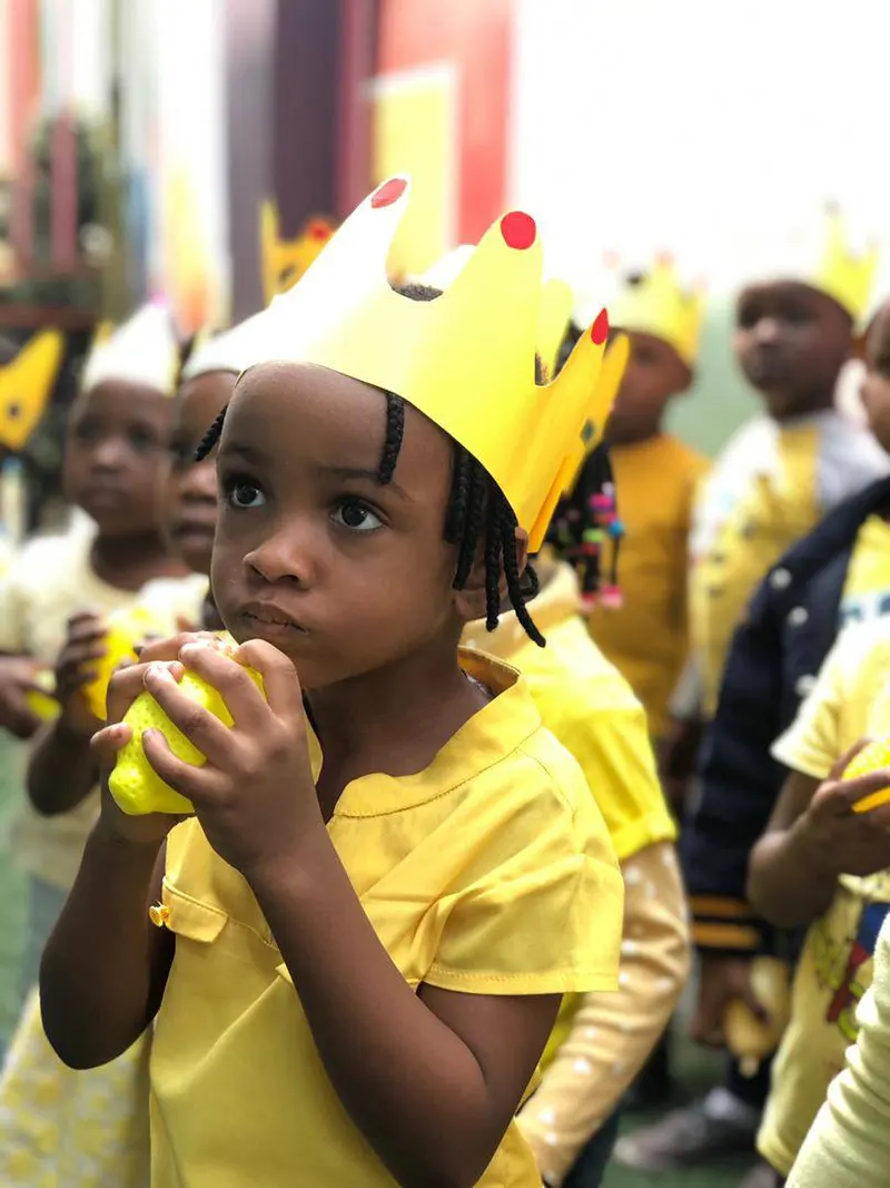 A young pupil wearing a paper crown during a school celebration