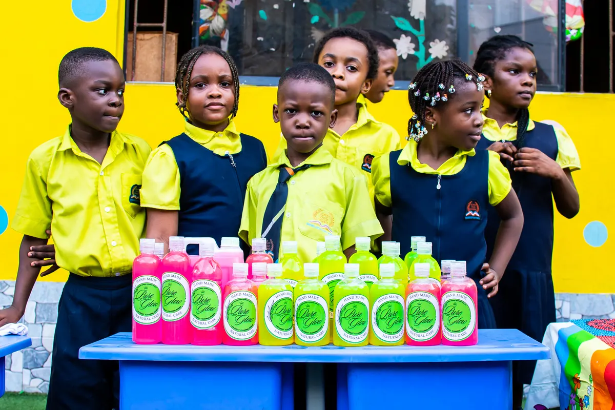Pupils in school uniform standing behind a table of products they made