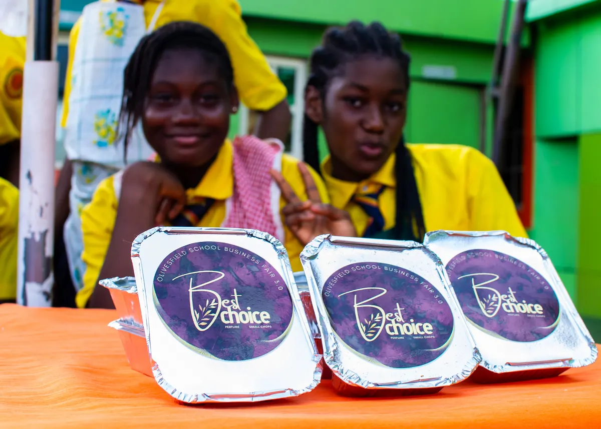 Two students smiling behind packaged food products they prepared
